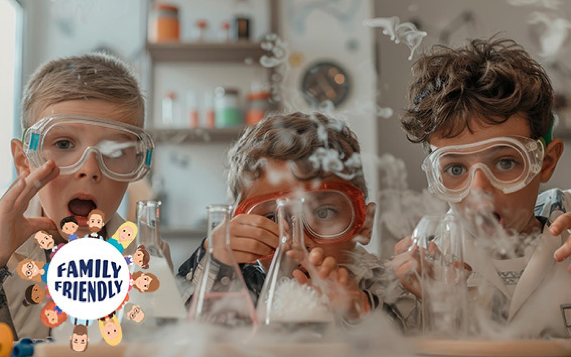 Drei Kinder mit Schutzbrillen führen ein lustiges wissenschaftliches Experiment mit Bechern und Trockeneis durch