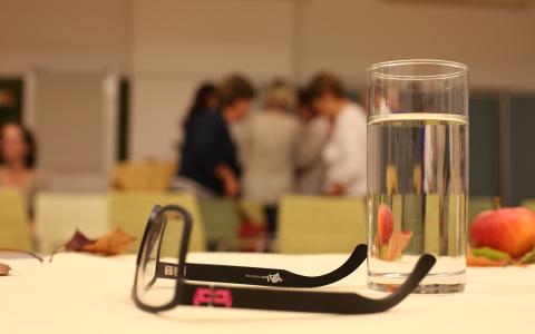 Am Tisch sind Lesebrille und Wasserglas